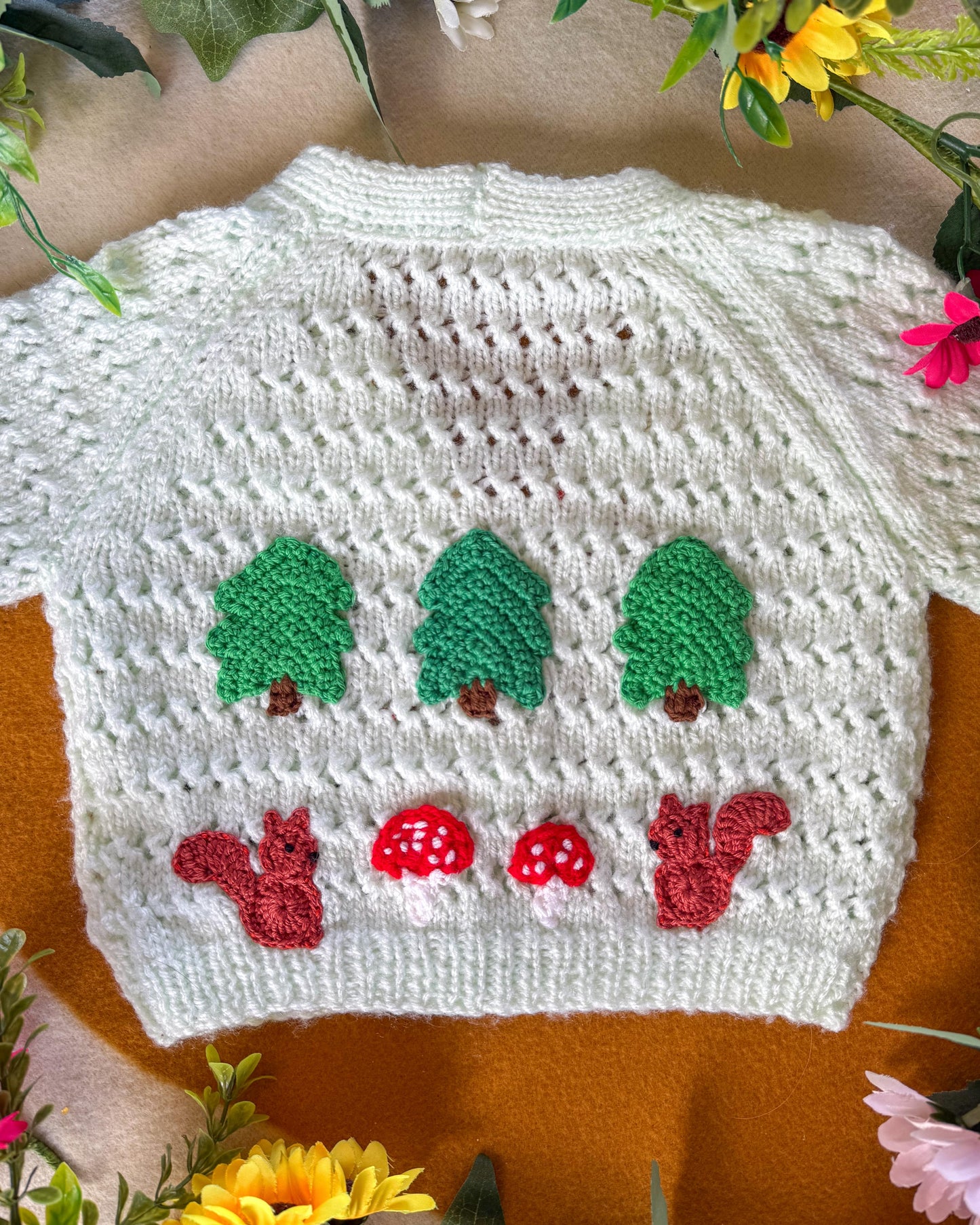 Handmade baby cardigan 9-12 months with woodland themed designs featuring trees and squirrels