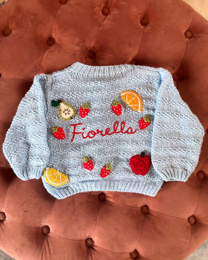 Light blue personalised baby cardigan UK with embroidered fruit and the name Fiorella on the back