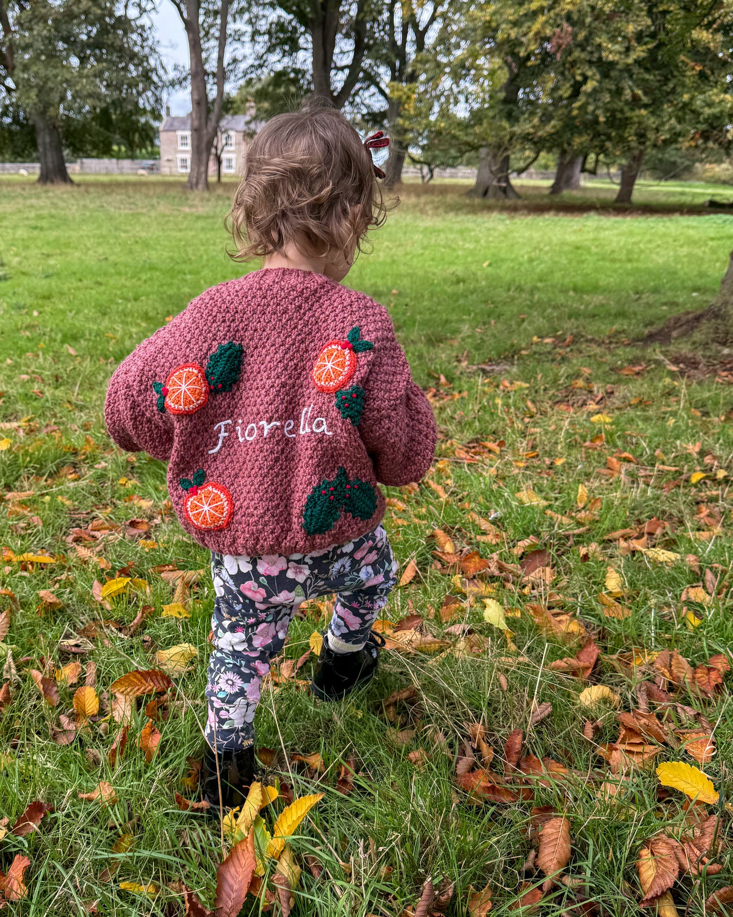 Personalised kids cardigan hand knitted in pink with fruit design, perfect for toddlers outdoors