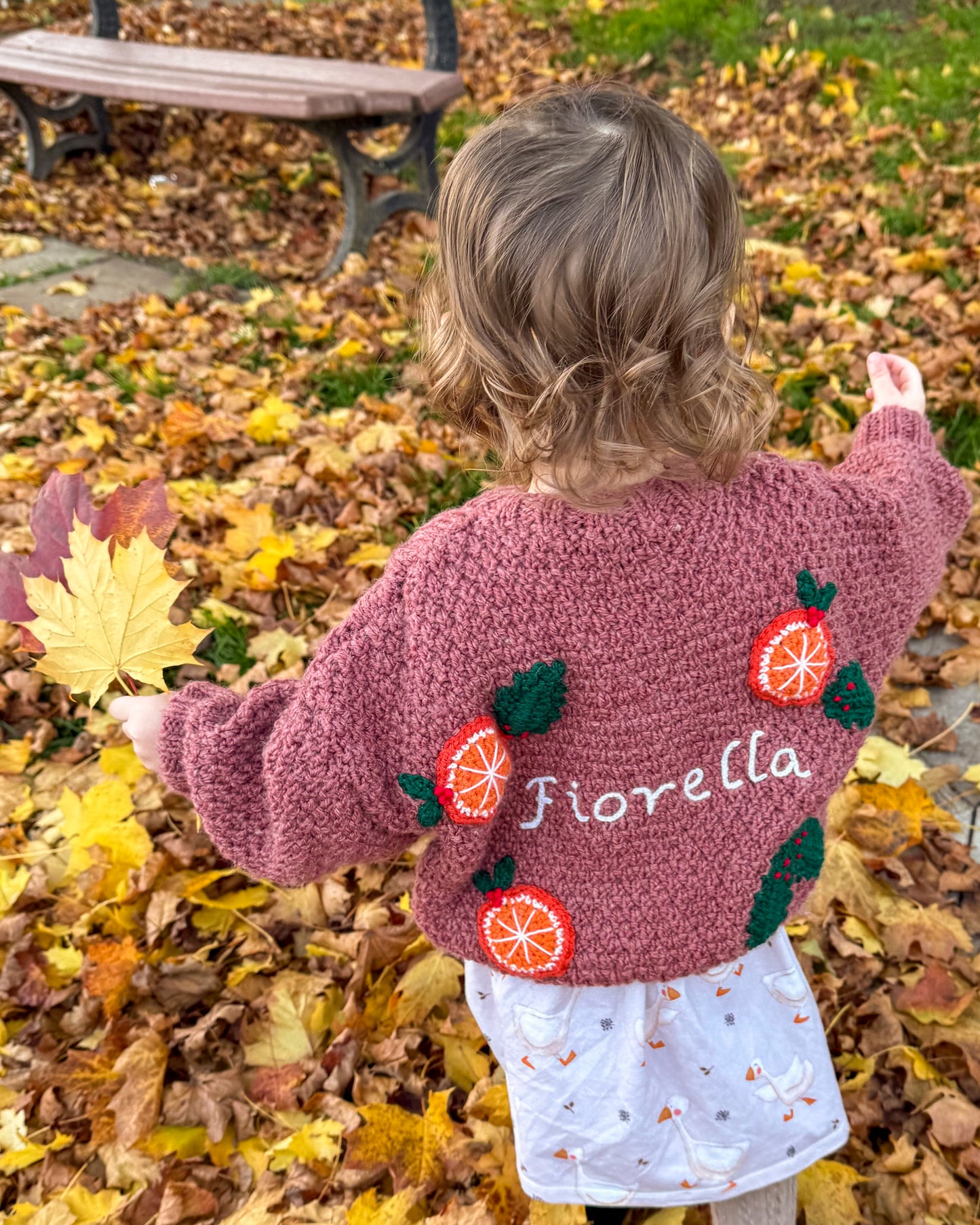 Personalised kids cardigan hand knitted in pink with embroidered oranges and child's name on the back