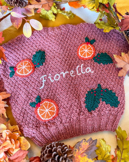 Personalised kids cardigan hand knitted with orange and holly motifs for a festive touch