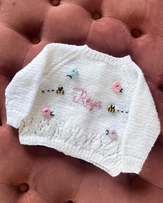 White personalised rose and bee cardigan with pastel floral and bee embroidery by Little Flower Knits