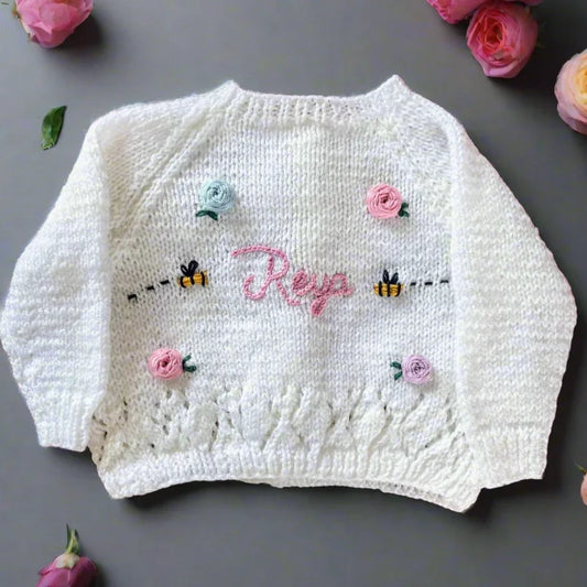 White sustainable kids knitwear with flowers featuring embroidered name and bees by Little Flower Knits