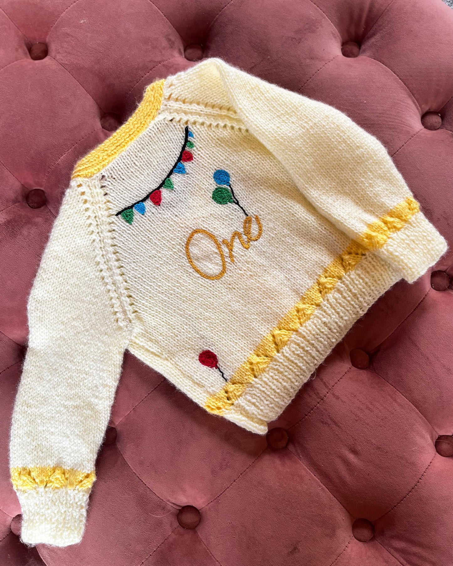 Little Flower Knits cream and yellow knitted cardigan with balloons and bunting, unique first birthday cardigan gift