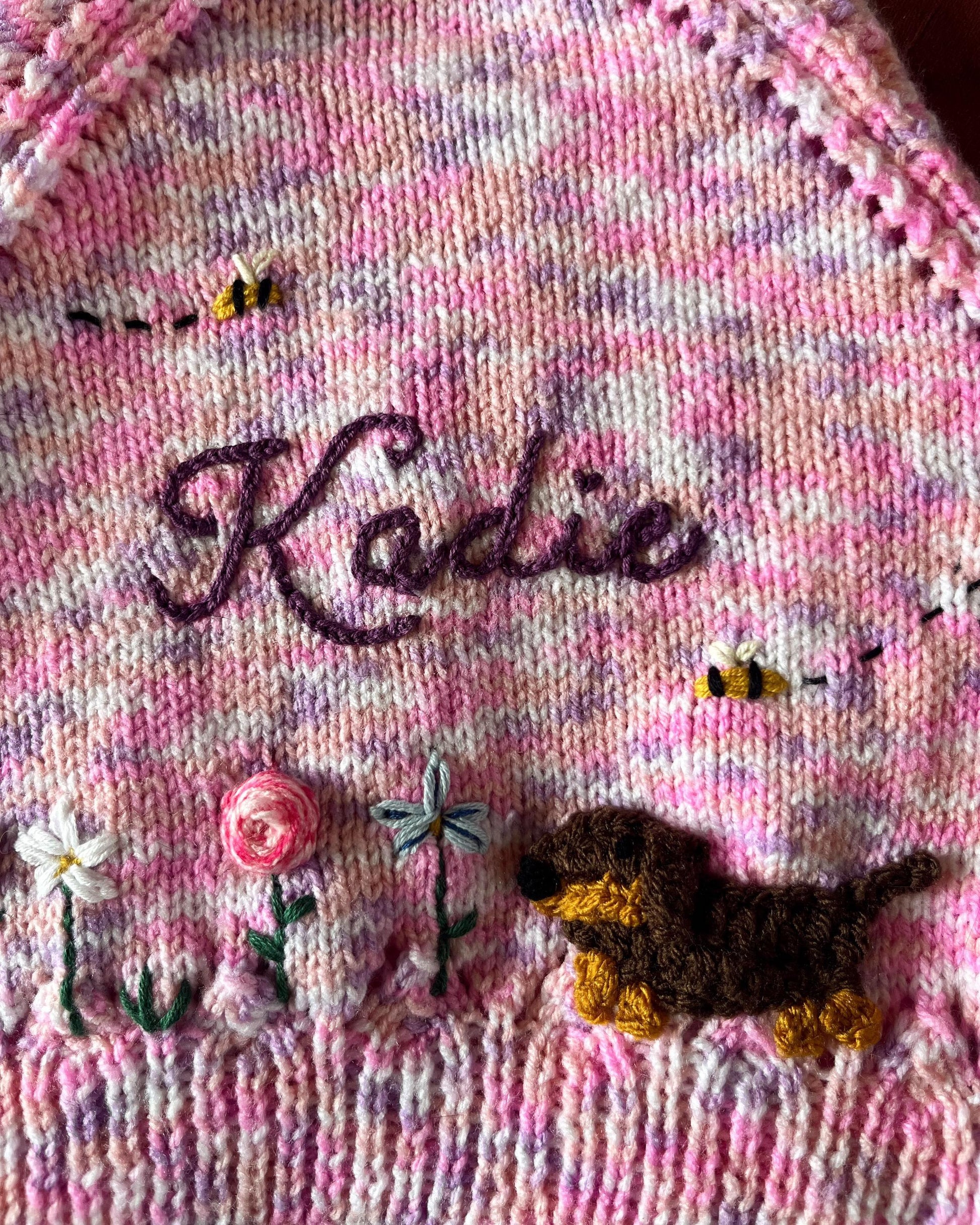 Little Flower Knits unique floral cardigan for girls in pink with embroidered name and knitted dog and flowers
