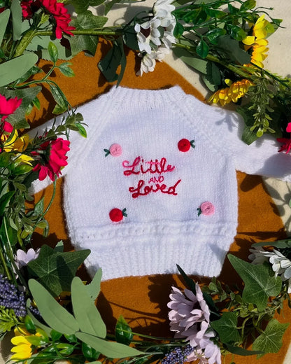 White baby jumper with Little Flower Knits unique personalised baby gift embroidery surrounded by colourful flowers