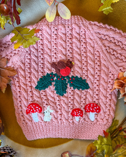 Hand-knitted winter woodland cardigan for toddlers featuring a robin and mushroom design