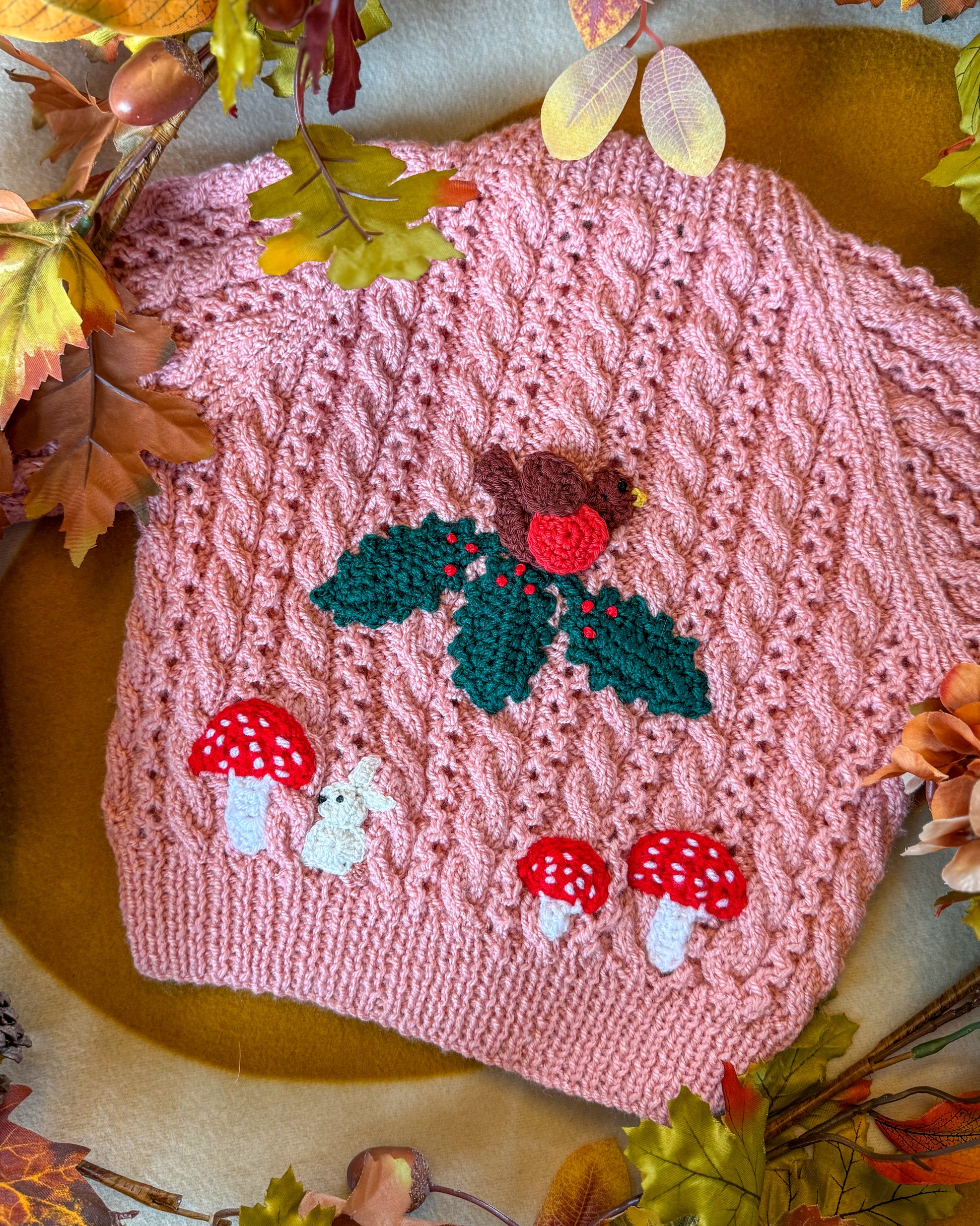 Hand-knitted winter woodland cardigan for toddlers in pink with woodland animal motifs
