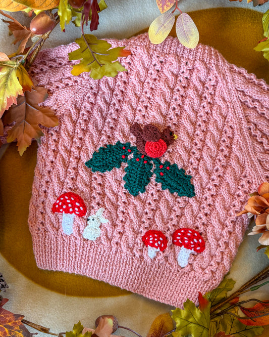 Hand-knitted winter woodland cardigan for toddlers in pink with woodland animal motifs