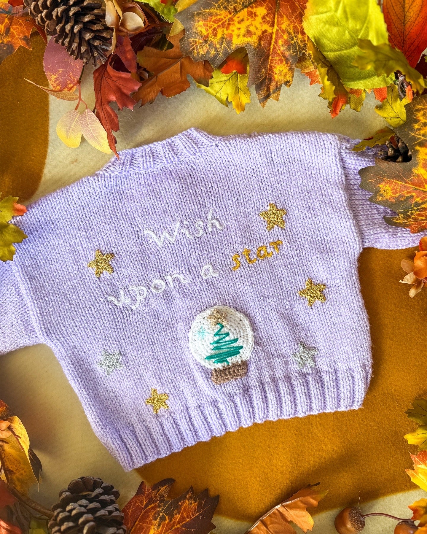 Little Flower Knits wish upon a star baby cardigan in lavender with embroidered stars and a tree design
