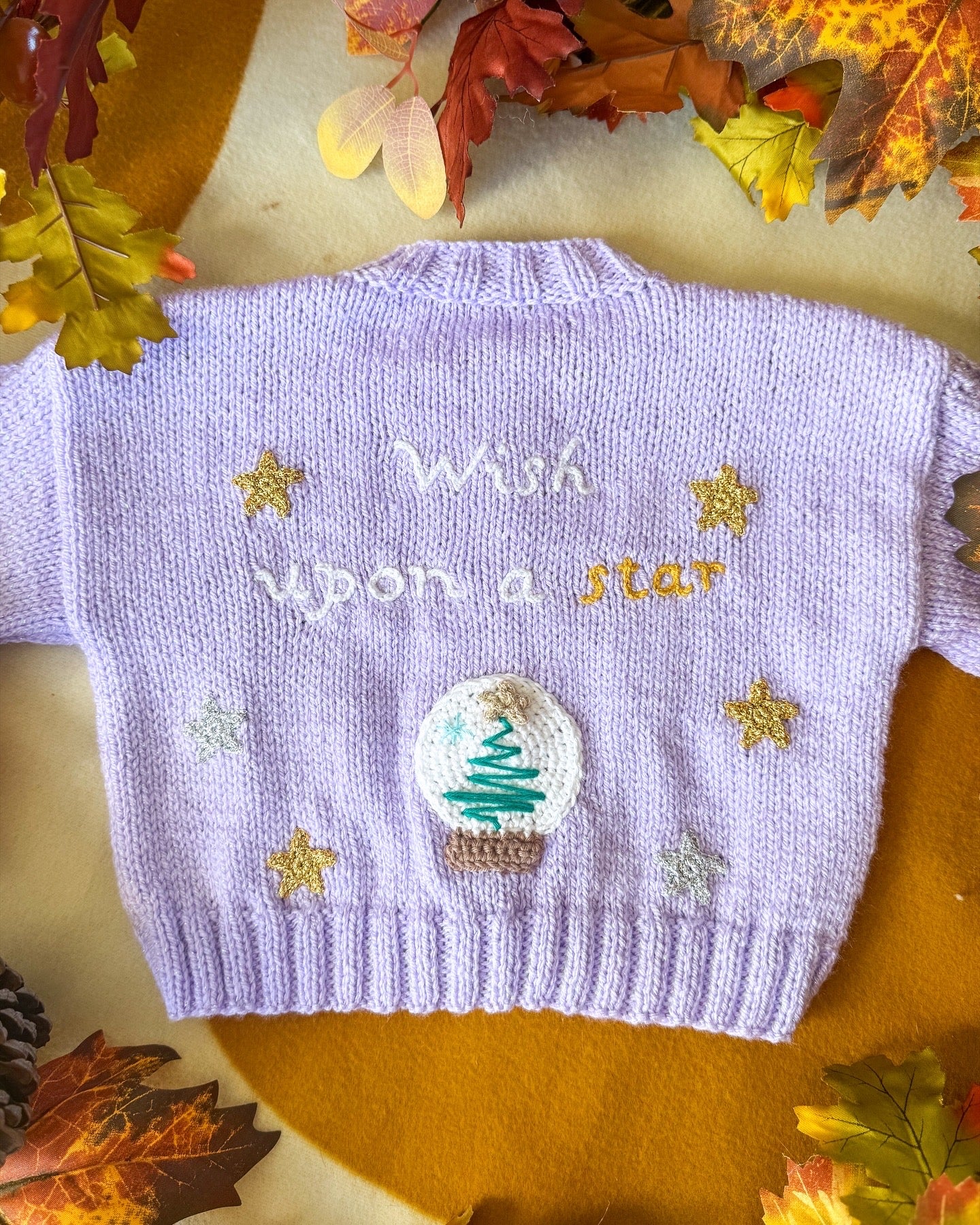 Lavender baby cardigan with 'Wish upon a star' and embroidered snow globe design by Little Flower Knits
